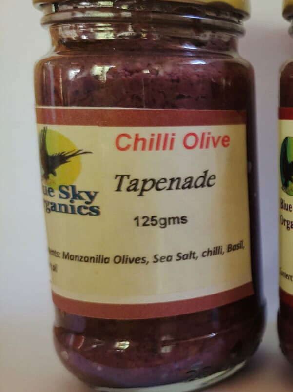 This is a product image showcasing our Olive Tapenade with Chilli. Made with finely chopped olives and a kick of chilli, it adds a bold and spicy element to your favourite meals.